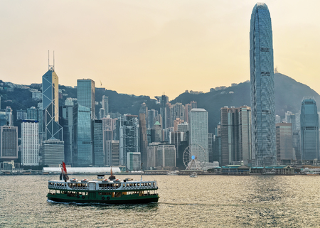 Star ferry at Victoria Harbor and Hong Kong skyline at sunset. View from Kowloon on HK Island.の写真素材
