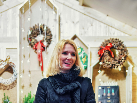 Vilnius, Lithuania - December 27, 2015: Smiling woman selling Christmas wreath on the Christmas Market in Vilnius. Selective focus. Filter is applied.のeditorial素材