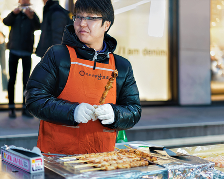 Seoul, South Korea - March 14, 2016: Woman seller of Kebab skewers in Myeongdong open street market in Seoul, South Koreaのeditorial素材