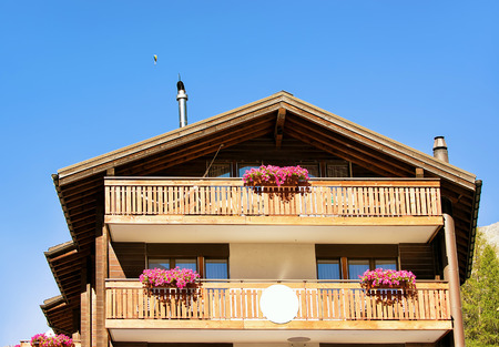 Traditional Swiss chalet with flowers on balconies in resort city Zermatt in Switzerland in summerの写真素材
