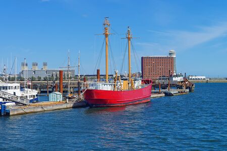 Red ship moored in the port in Boston, the United States. The Port of Boston is the major seaport in Massachusetts. Historically, it was an entry point for many immigrants.の写真素材