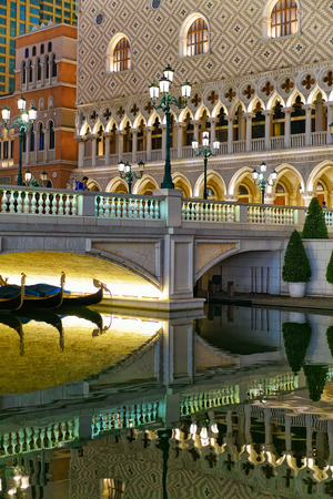 Macao, China - March 8, 2016: Waterfront in Venetian Macau Casino and Hotel, luxury resort in Macao, China. People on the background. Late in the evening. Golden light illuminationのeditorial素材