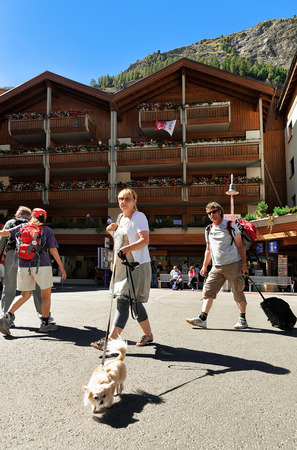 Zermatt, Switzerland - August 24, 2016: Travelers with pet at the tourist information office in the City center of Zermatt in Switzerland.のeditorial素材