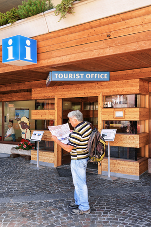 Zermatt, Switzerland - August 24, 2016: Tourist looking into the city map at the tourist office of Zermatt in Switzerland.のeditorial素材