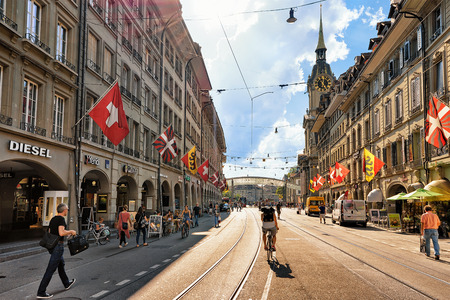 Bern, Switzerland - August 31, 2016: People on Spitalgasse street with shopping area in old city center of Bern, Switzerland. Steeple of Holy Spirit Church on the backgroundのeditorial素材