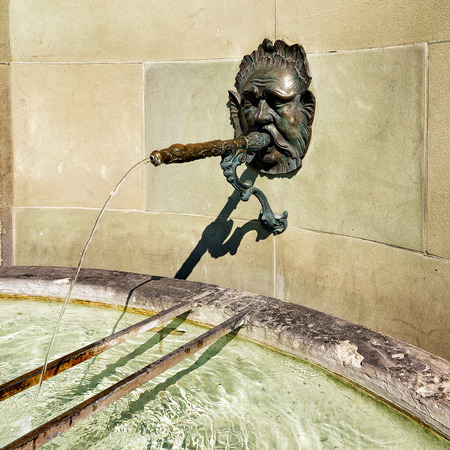 Bern, Switzerland - August 31, 2016: Fragment of fountain with water at old city center of Bern, Switzerlandのeditorial素材