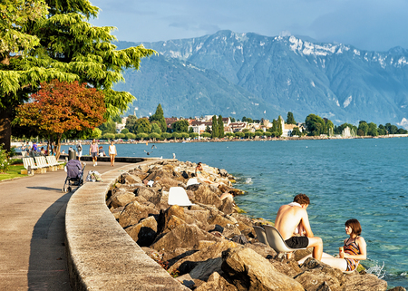 Vevey, Switzerland - August 27, 2016: People sunbathing at the embankment on Geneva Lake in Vevey, Vaud canton, Switzerlandのeditorial素材