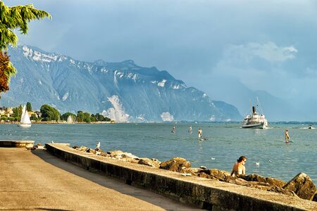 Vevey, Switzerland - August 27, 2016: Excursion ferry and peope at Geneva Lake in Vevey, Vaud canton, Switzerland. Alps mountains on the backgroundのeditorial素材