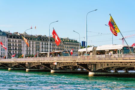 Geneva, Switzerland - August 30, 2016: Mont Blanc bridge with Swiss flags over Geneva Lake in Geneva city, Switzerland. People on the backgroundのeditorial素材