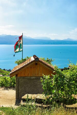 Shelter house with flag at Vineyard Terraces hiking trail of Lavaux, Lake Geneva and Swiss mountains, Lavaux-Oron district of Switzerlandの写真素材