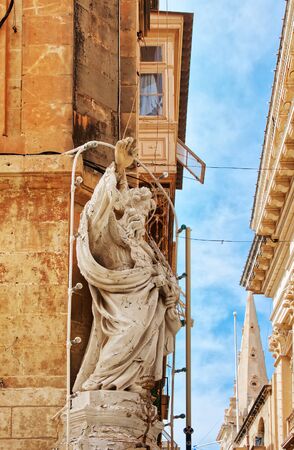 Figure of a Saint at the corner of the street in Valletta old town, Maltaの写真素材