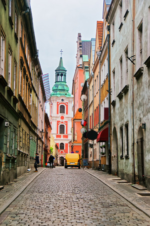 Poznan, Poland - May 7, 2014: Cobblestone Street leading to St Stanislaus Church in the Old town of Poznan, Poland. People on the backgroundのeditorial素材