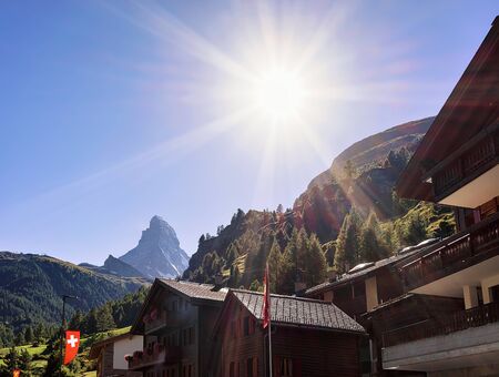 Traditional Swiss Chalets in Zermatt with Matterhorn summit with flags, Switzerland in summer.の写真素材