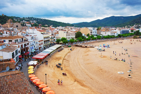 Beach with people in Tossa de Mar on the Costa Brava at the Mediterranean Sea in Spain.の写真素材