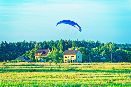 Paraglider flies over with the parachute in Polandの写真素材