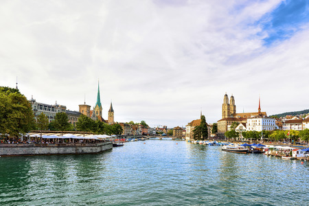Limmat River Quay with boats and three main churches of Zurich - Grossmunster, Fraumunster and St Peter Church, in Switzerlandの写真素材