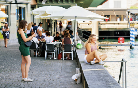 Zurich, Switzerland - September 2, 2016: Young girls taking photos at Limmat River quay in the old city center of Zurich, Switzerlandのeditorial素材