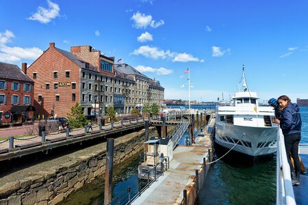 Boston, USA - April 28, 2015: Boats floating on water in the harbor in Boston, MA, the United States. People aboardのeditorial素材