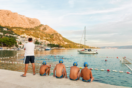 Omis, Croatia - August 17, 2016: Water polo reserve players and trainer watching the match in Omis, Croatiaのeditorial素材
