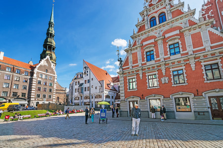 Riga, Latvia - September 3, 2014: Square with people and House of Blackheads and St Peter Church in the historical center in the old town of Riga, Latvia.のeditorial素材