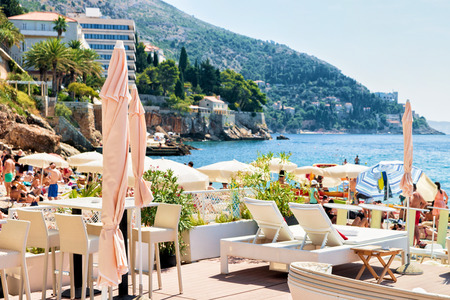 Dubrovnik, Croatia - August 19, 2016: Shelters and deckchairs on beach at Adriatic Sea, Dubrovnik, Croatiaのeditorial素材