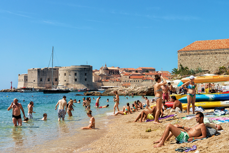 Dubrovnik, Croatia - August 20, 2016: People in beach at Adriatic Sea and Dubrovnik fortress, Croatiaのeditorial素材