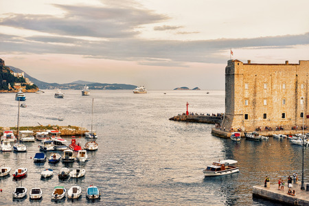 Dubrovnik, Croatia - August 19, 2016: Evening at St John Fort and Sailing boats and people at the Old port in the Adriatic Sea in Dubrovnik, Croatiaのeditorial素材