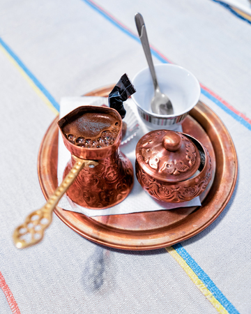 Black coffee in old copper jezve on the tray in a restaurantの写真素材