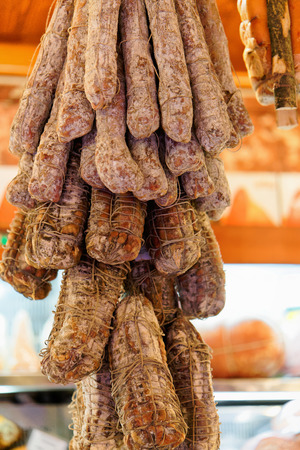 Cured italian smoked sausage hanging at the stall on Bologna market, Italyの写真素材