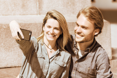 Young girl making selfie with her boyfriend as friendship and togetherness conceptの写真素材