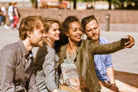 Young middle eastern girl making selfie with her friends via the mobile phone Conceptの写真素材