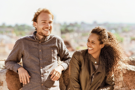 Smiling young mixed race girl with caucasian friend standing and relaxing together as diversity friendship and togetherness conceptの写真素材