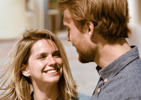 Smiling young couple looking at each other tenderly as love conceptの写真素材