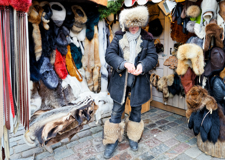 Riga, Latvia - December 24, 2015: Male seller of fur items on Christmas market in Riga, Latviaのeditorial素材
