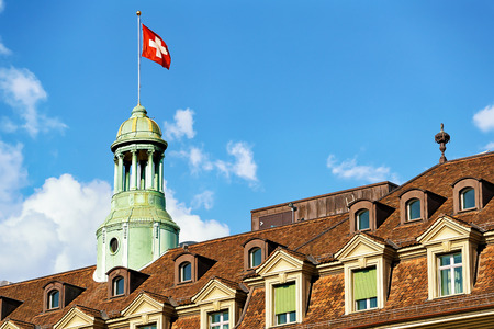 Tower with Swiss flag and roof covered with tiles in Bern, Switzerlandの写真素材