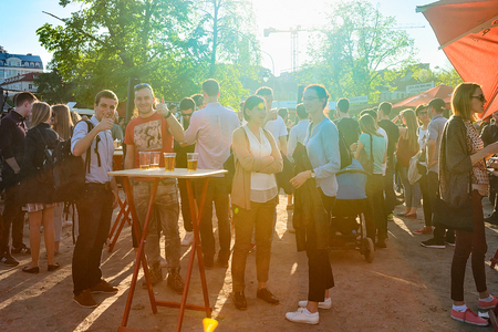 Vilnius, Lithuania - May 19, 2017: Young people eating and drinking beer at Open Kitchen food...