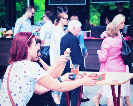 Vilnius, Lithuania - June 9, 2017: Girls taking photos of beer at Open Kitchen food festival in Vilnius, Lithuania.のeditorial素材