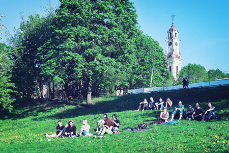 Vilnius, Lithuania - May 19, 2017: Young people sitting on the green grass, in Vilnius, Lithuania.のeditorial素材