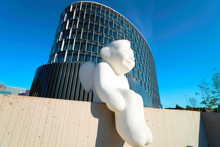 Vilnius, Lithuania - August 8, 2017: Angel sculpture at modern steel and glass forum skyscraper reflecting the blue skyのeditorial素材