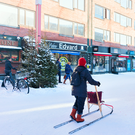 Rovaniemi, Finland - March 4, 2017: Senior woman with her ski walker crossing the street of winter Rovaniemi, Finland.のeditorial素材