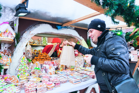 Riga, Latvia - December 28, 2016: Man at the stall on Christmas Market at Dome Square in Riga Old Town in winterのeditorial素材