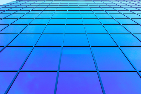 Windows of modern futuristic glass skyscraper reflecting the blue sky の写真素材