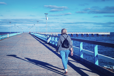 Woman with backpack at the Sea Bridge over the Baltic sea in Palanga resort, Lithuaniaの写真素材