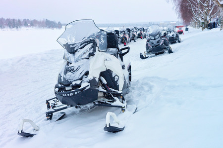 Black snowmobiles in the frozen lake in winter Rovaniemi, Lapland, Finlandの写真素材