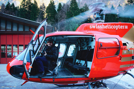 Gsteigwiler, Switzerland - December 31, 2013: Man in the cabin of a helicopter at Swiss Alpine heliport in winter, Gsteigwiler, in Switzerlandのeditorial素材