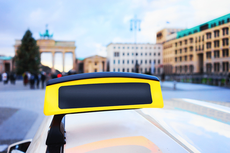 Empty Taxi sign board in the street of Berlin, Germany. Brandenburg gate on the backgroundの写真素材