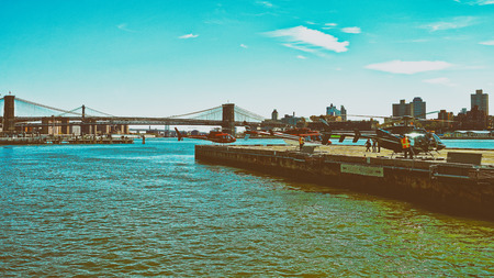 New York, USA - April 25, 2015: Helicopters on helipad in Pier 6 at Lower Manhattan, New York, the USA, East River. Skyscrapers of Brooklyn on the background. Person on the pad.のeditorial素材