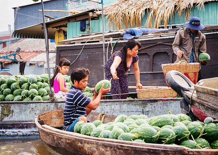 Can Tho, Vietnam - February 28, 2016: Family selling watermelons in a boat at the Floating market at the delta Mekong in Can Tho, Vietnamのeditorial素材