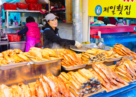 Busan, South Korea - March 12, 2016: Sellers of fried fish in street Fish market in Jagalchi in Busan, South Koreaのeditorial素材