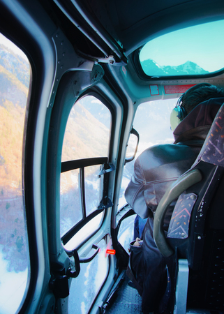 Gsteigwiler, Switzerland - December 31, 2013: Man at the cabin of a helicopter in Swiss Alpine heliport in winter, Gsteigwiler, in Switzerlandのeditorial素材